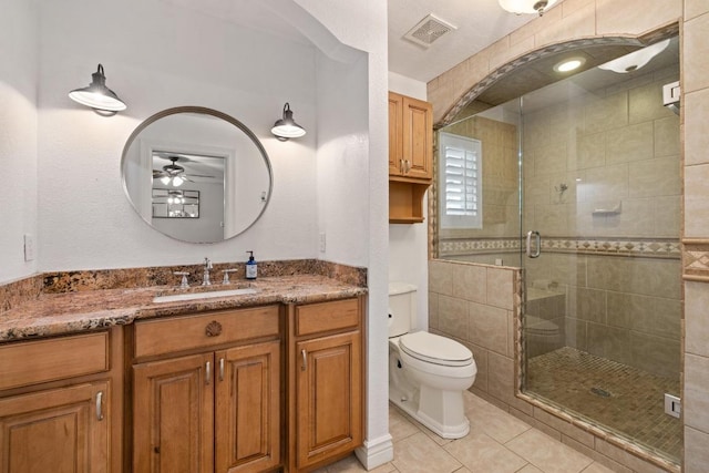 13201 Stillforest St, Austin, TX 78729 - full bathroom with a shower stall, vanity, tile patterned floors, ceiling fan, and toilet