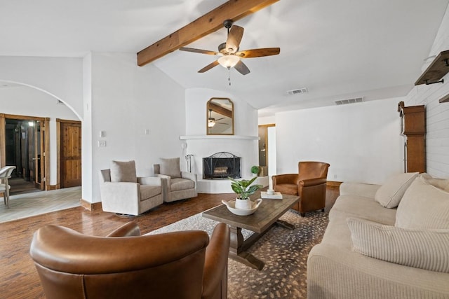 13201 Stillforest St, Austin, TX 78729 - living room with arched walkways, a fireplace with raised hearth, a ceiling fan, and wood finished floors