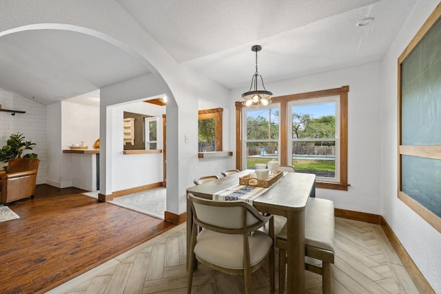 13201 Stillforest St, Austin, TX 78729 - dining space with baseboards, arched walkways, vaulted ceiling, and a chandelier