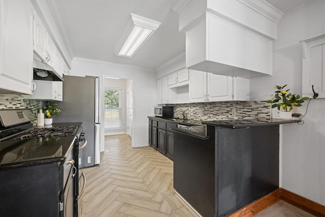 13201 Stillforest St, Austin, TX 78729 - kitchen featuring range with gas cooktop, under cabinet range hood, dark countertops, stainless steel microwave, and white cabinetry