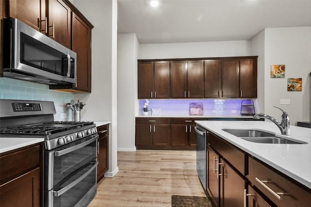 320 Bright Star Ln, Georgetown, TX 78628 - kitchen featuring appliances with stainless steel finishes, light wood-style flooring, light countertops, backsplash, and recessed lighting