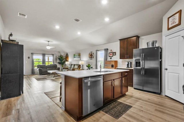 320 Bright Star Ln, Georgetown, TX 78628 - kitchen with appliances with stainless steel finishes, light wood-type flooring, light countertops, lofted ceiling, and a center island with sink