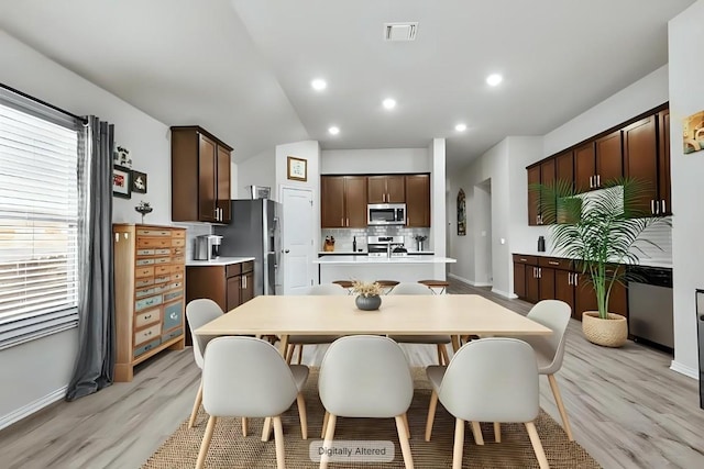 320 Bright Star Ln, Georgetown, TX 78628 - dining space with light wood finished floors, vaulted ceiling, and recessed lighting