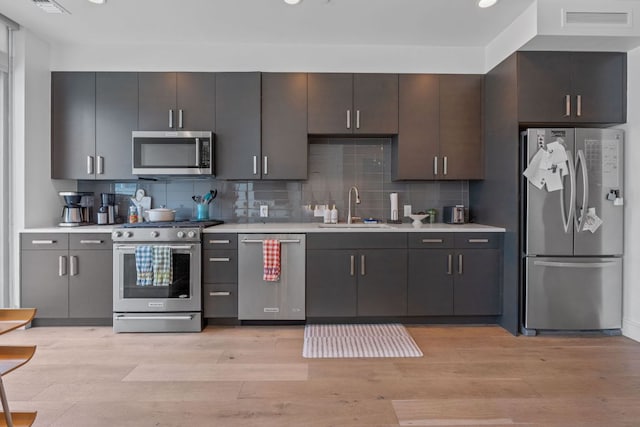 222 W Ave Unit 1001, Austin, TX 78701 - kitchen featuring appliances with stainless steel finishes, a sink, light countertops, decorative backsplash, and recessed lighting