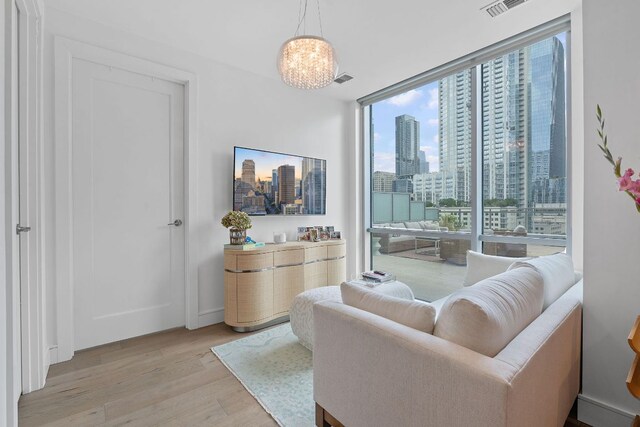 222 W Ave Unit 1001, Austin, TX 78701 - living area with light wood-type flooring, expansive windows, and a chandelier
