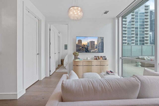 222 W Ave Unit 1001, Austin, TX 78701 - living area with wood finished floors, a chandelier, a city view, expansive windows, and baseboards