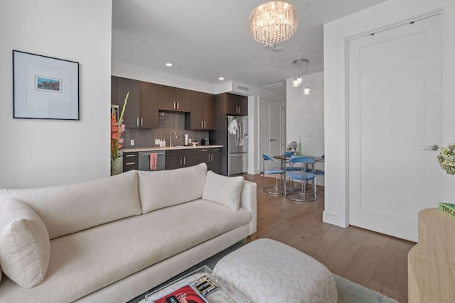 222 W Ave Unit 1001, Austin, TX 78701 - living area with wood finished floors, a chandelier, bar with sink, and recessed lighting