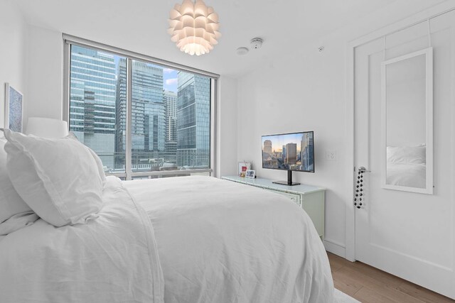 222 W Ave Unit 1001, Austin, TX 78701 - bedroom with expansive windows and wood finished floors