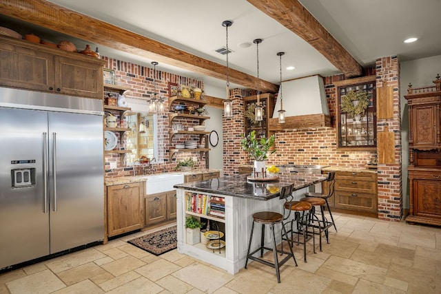1606 Bordeaux Blanc, New Braunfels, TX 78132 - kitchen with open shelves, stainless steel built in fridge, beam ceiling, stone tile floors, and a breakfast bar