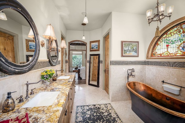 1606 Bordeaux Blanc, New Braunfels, TX 78132 - full bath with tile walls, a soaking tub, double vanity, a wainscoted wall, and tile patterned flooring