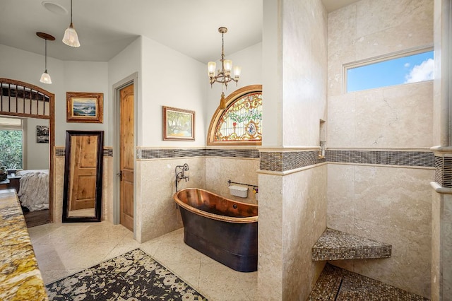1606 Bordeaux Blanc, New Braunfels, TX 78132 - full bathroom featuring tile walls, a soaking tub, connected bathroom, wainscoting, and a chandelier