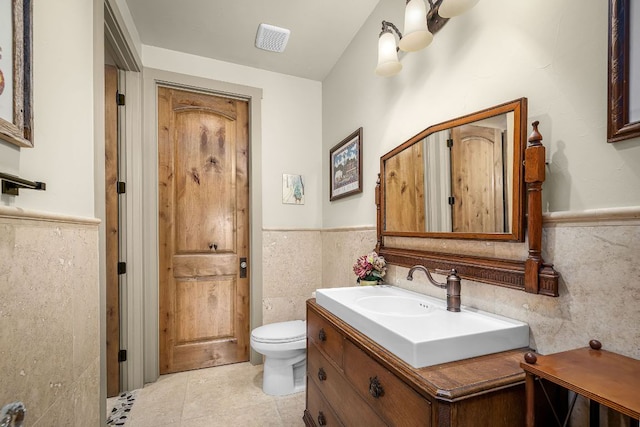 1606 Bordeaux Blanc, New Braunfels, TX 78132 - bathroom featuring tile walls, vanity, toilet, wainscoting, and tile patterned floors