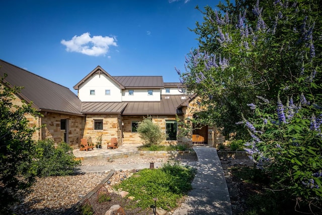 1606 Bordeaux Blanc, New Braunfels, TX 78132 - back of property with stone siding, metal roof, and a standing seam roof
