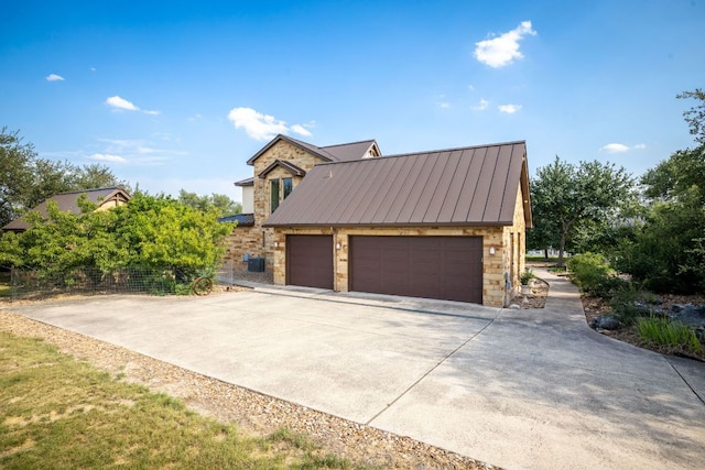 1606 Bordeaux Blanc, New Braunfels, TX 78132 - view of property exterior featuring stone siding, concrete driveway, a standing seam roof, and metal roof