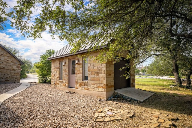 1606 Bordeaux Blanc, New Braunfels, TX 78132 - view of property exterior with stone siding, a standing seam roof, an outbuilding, and metal roof