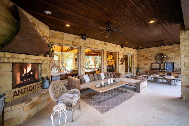 1606 Bordeaux Blanc, New Braunfels, TX 78132 - living room featuring a ceiling fan, an outdoor stone fireplace, wooden ceiling, and concrete flooring