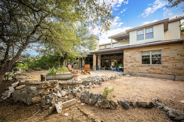1606 Bordeaux Blanc, New Braunfels, TX 78132 - back of house featuring a patio area, stone siding, a chimney, and stucco siding