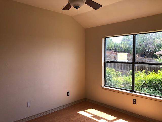 22340 Briarcliff Dr, Spicewood, TX 78669 - unfurnished room featuring wood finished floors, a ceiling fan, lofted ceiling, and baseboards