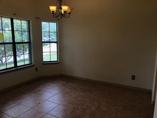 22340 Briarcliff Dr, Spicewood, TX 78669 - spare room featuring a chandelier, dark tile patterned floors, and baseboards