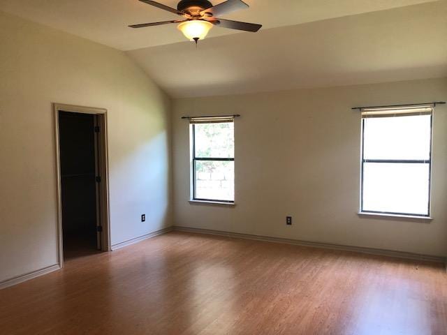 22340 Briarcliff Dr, Spicewood, TX 78669 - spare room featuring light wood-style flooring, ceiling fan, lofted ceiling, and baseboards
