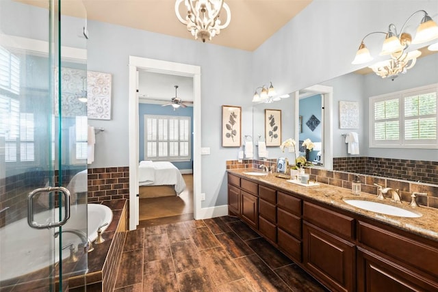 121 White Wash, Dripping Springs, TX 78620 - ensuite bathroom featuring a chandelier, double vanity, a stall shower, baseboards, and backsplash