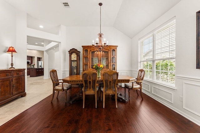 2600 Lost Mine Trl, Leander, TX 78641 - dining space featuring a chandelier, a decorative wall, hardwood / wood-style flooring, wainscoting, and vaulted ceiling