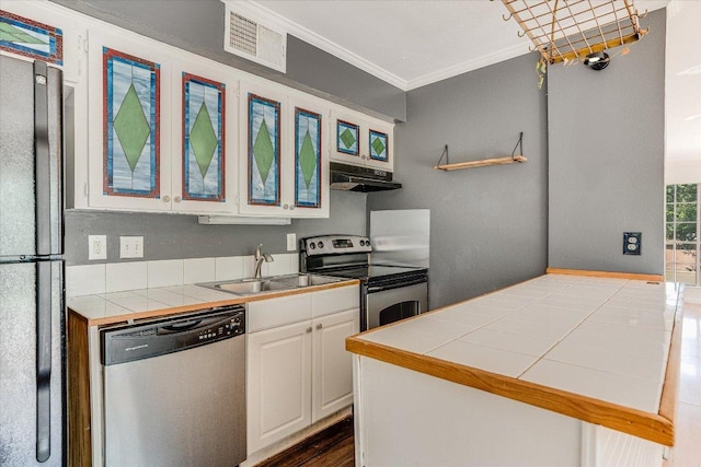 3304 Clawson Rd, Austin, TX 78704 - kitchen featuring stainless steel appliances, a sink, under cabinet range hood, tile countertops, and ornamental molding