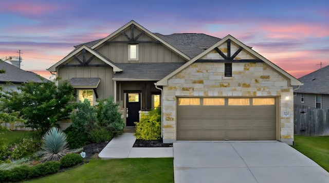 202 Westfield St, Hutto, TX 78634 - view of front of home featuring board and batten siding, stone siding, concrete driveway, a shingled roof, and an attached garage
