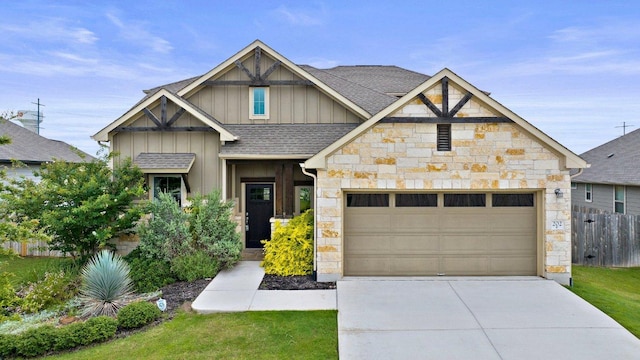 202 Westfield St, Hutto, TX 78634 - craftsman house with board and batten siding, stone siding, a shingled roof, driveway, and a garage