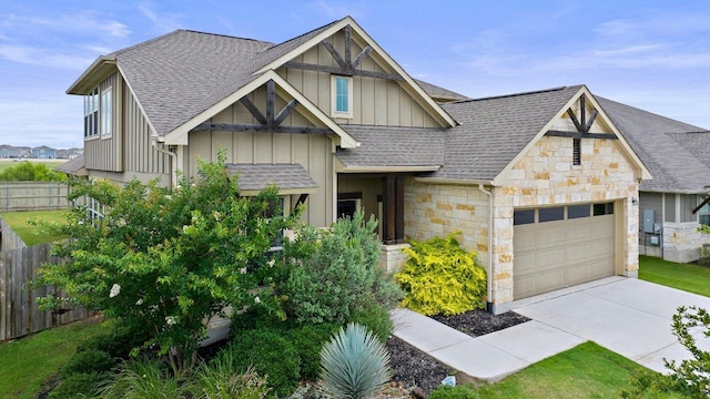 202 Westfield St, Hutto, TX 78634 - view of front of home with stone siding, an attached garage, board and batten siding, roof with shingles, and driveway
