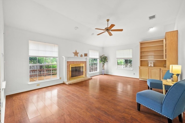 10601 Beckwood Dr, Austin, TX 78726 - living area featuring a ceiling fan, healthy amount of natural light, a brick fireplace, and wood finished floors