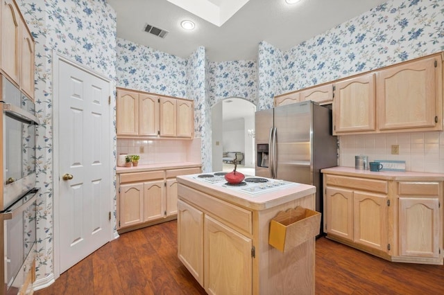 10601 Beckwood Dr, Austin, TX 78726 - kitchen featuring light brown cabinetry, wallpapered walls, appliances with stainless steel finishes, and dark wood-style floors