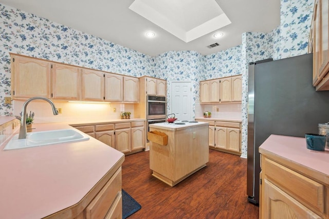 10601 Beckwood Dr, Austin, TX 78726 - kitchen with wallpapered walls, light brown cabinets, a sink, appliances with stainless steel finishes, and dark wood-style floors