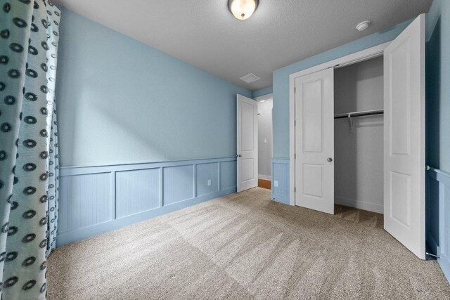 20525 Martin Ln, Pflugerville, TX 78660 - unfurnished bedroom featuring carpet, a closet, and a wainscoted wall