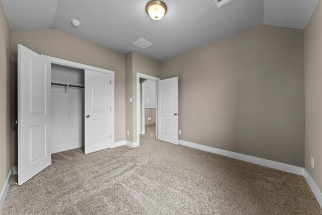 20525 Martin Ln, Pflugerville, TX 78660 - unfurnished bedroom with vaulted ceiling, carpet, a closet, and baseboards
