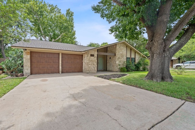 1515 Mearns Meadow Blvd, Austin, TX 78758 - mid-century home featuring stone siding, a garage, driveway, and a front lawn