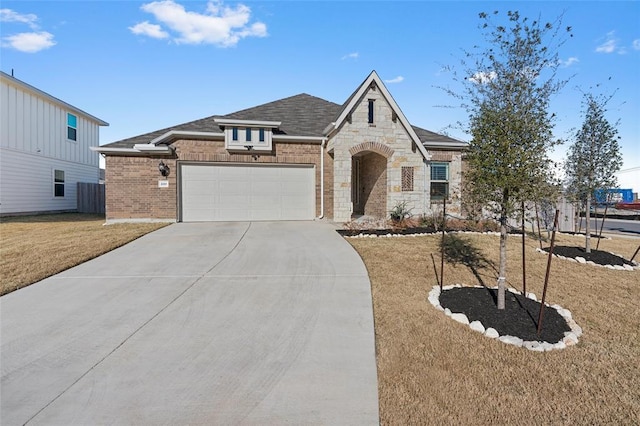200 Ottaviano Way, Hutto, TX 78634 - view of front of home with a garage, driveway, a front yard, brick siding, and stone siding