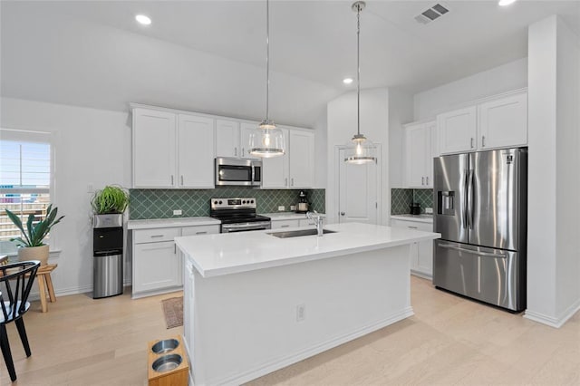 200 Ottaviano Way, Hutto, TX 78634 - kitchen featuring appliances with stainless steel finishes, a sink, light wood-style floors, light countertops, and decorative backsplash