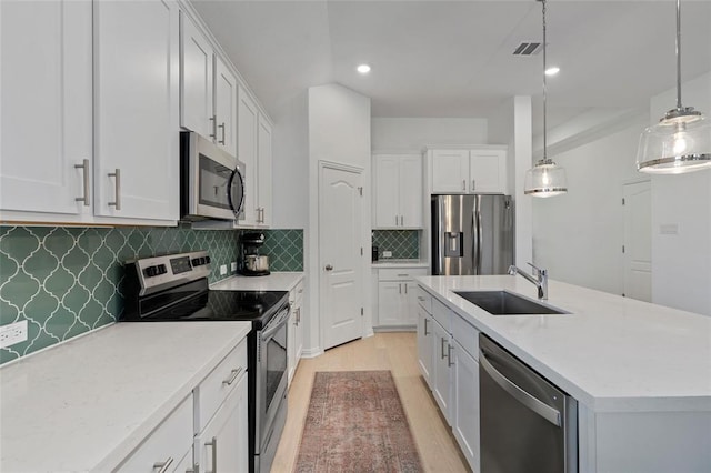 200 Ottaviano Way, Hutto, TX 78634 - kitchen with appliances with stainless steel finishes, a sink, light wood-style flooring, a center island with sink, and light countertops