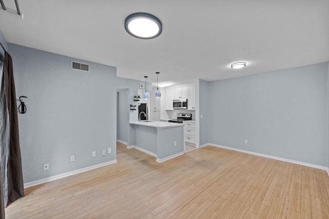 3204 Menchaca Rd Unit 405, Austin, TX 78704 - kitchen featuring stainless steel appliances, white cabinetry, a peninsula, light wood finished floors, and light countertops