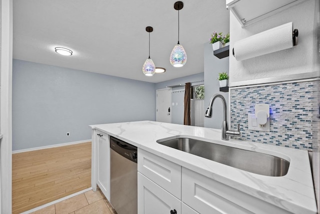 3204 Menchaca Rd Unit 405, Austin, TX 78704 - kitchen featuring stainless steel dishwasher, white cabinets, hanging light fixtures, tasteful backsplash, and light stone countertops