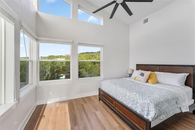 11204 Oak St, Jonestown, TX 78645 - bedroom with high vaulted ceiling, multiple windows, light wood-type flooring, baseboards, and a ceiling fan