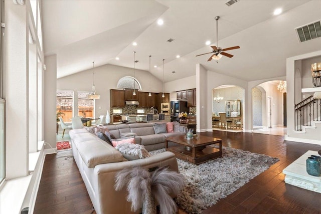 2997 Agave Loop, Round Rock, TX 78681 - living room featuring arched walkways, ceiling fan, high vaulted ceiling, dark wood-type flooring, and stairway