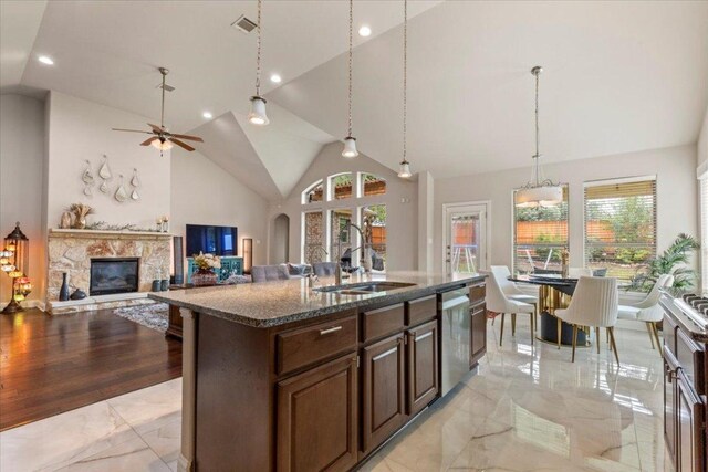 2997 Agave Loop, Round Rock, TX 78681 - kitchen featuring stainless steel dishwasher, light marble finish floors, healthy amount of natural light, dark stone countertops, and recessed lighting