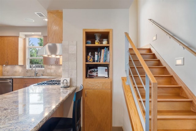 148 Oak Plaza Dr, Georgetown, TX 78628 - kitchen with stainless steel appliances, light stone countertops, tasteful backsplash, a sink, and exhaust hood