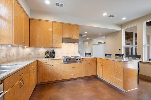 148 Oak Plaza Dr, Georgetown, TX 78628 - kitchen with stainless steel gas cooktop, a peninsula, finished concrete flooring, decorative backsplash, and under cabinet range hood