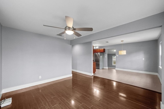 5601 Samuel Huston Ave, Austin, TX 78721 - unfurnished living room featuring ceiling fan, wood finished floors, and baseboards