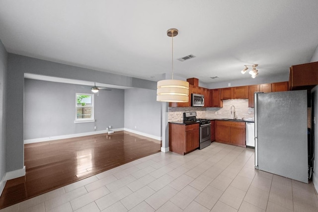 5601 Samuel Huston Ave, Austin, TX 78721 - kitchen featuring stainless steel appliances, a sink, decorative backsplash, open floor plan, and ceiling fan
