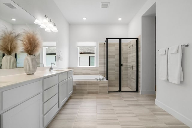 256 Smoke Tree Cir, Dripping Springs, TX 78620 - bathroom with a garden tub, double vanity, a stall shower, recessed lighting, and tile patterned flooring