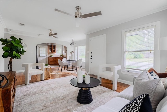 3210 Funston St, Austin, TX 78703 - living area with ceiling fan, light wood finished floors, ornamental molding, arched walkways, and a chandelier